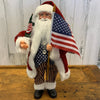 "15 Inch Santa Claus Home Decor In Blue Stars Spangled Vest and Red Jacket and Hat Holding the American Flag with Pole and a Libery Statue in Flag Design"