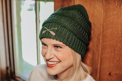 Green Knitted Beanie Hat With Embroidered Brown Crossed Paddle Design