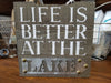 Dark Brown Wood and Metal Wall Plaque Featuring White Text "Life is Better at the Lake" Sentiment