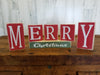 Red and Green Wooden Block Sign Featuring "M-E-R-R-Y" Letters in Every Red Block and "Christmas" Text In a Green Block Sign