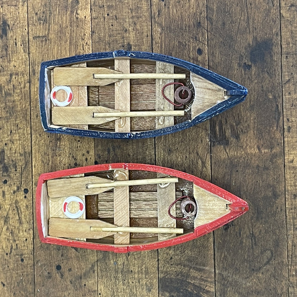 Red and Blue Wooden Row Boat Ornament Featuring Wooden Oars and Life Ring on it